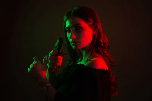 Kulüpte Karanlıkta Oturan Genç Güzel Bir Kadın Elinde Silah Tutuyor — Stok fotoğraf