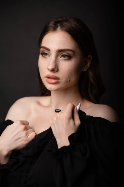 Karanlık bir arka planda güzel bir kızın portresi. Stüdyoda şık bir fotoğraf var..