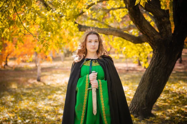 中世の緑のドレスを着た美しい少女が手に短剣を持っている クロークの女王と秋の森のブロイオドレス 歴史像 — ストック写真