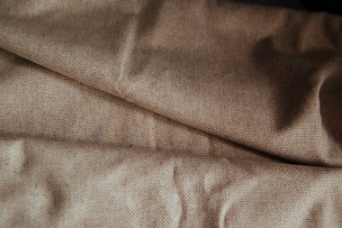 Örtü için bej kumaş. Katlanmış bir parça pamuk. Buruşmuş Doku