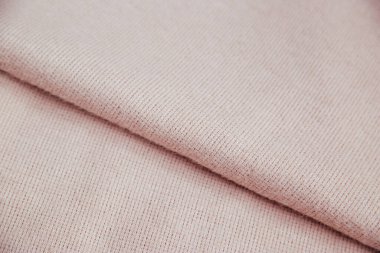 Kumaşlar için pembe yumuşacık kumaş. Kıvrımlı sıcak bir bez parçası. Buruşuk ve pürüzlü doku