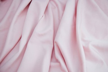 Kırışık açık pembe kumaş kıvrımlar ve kumaşlarda yatıyor. Pembe renkli tekstil dokusu