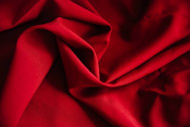 Kırmızı kırışık kumaş örtüsü. Dikiş malzemesi masanın üstünde. Dikiş dokusu