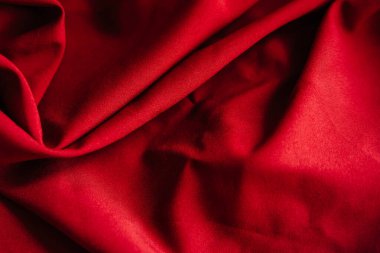 Kırmızı kırışık kumaş örtüsü. Dikiş malzemesi masanın üstünde. Dikiş dokusu