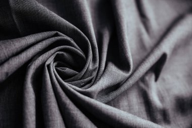 Gri buruşuk kumaş. Dikiş malzemesi masanın üstünde. Katlanmış dikiş dokusu