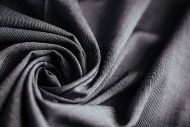 Gri buruşuk kumaş. Dikiş malzemesi masanın üstünde. Katlanmış dikiş dokusu