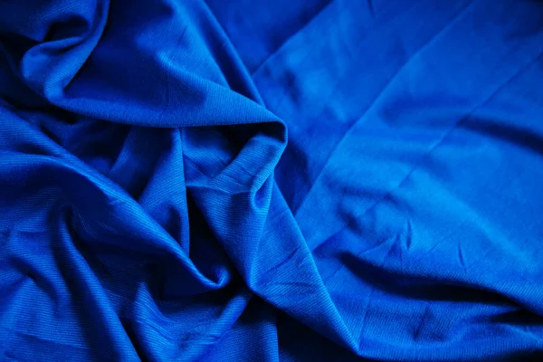 青いしわのドレープ生地 ミシンの材料がテーブルの上にある 折り目付きの縫製用テクスチャ — ストック写真