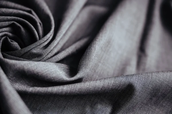 Gri buruşuk kumaş. Dikiş malzemesi masanın üstünde. Katlanmış dikiş dokusu