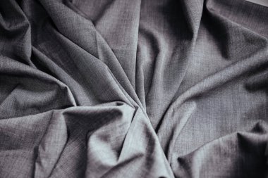 Gri buruşuk kumaş. Dikiş malzemesi masanın üstünde. Katlanmış dikiş dokusu