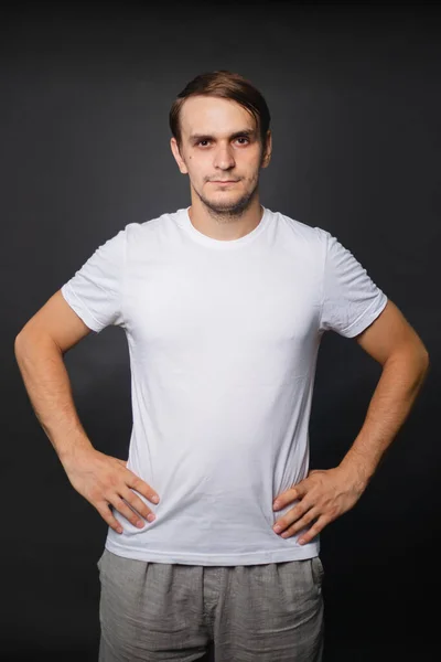 Jovem Bonito Uma Camiseta Branca Fica Fundo Cinza Roupa Para — Fotografia de Stock