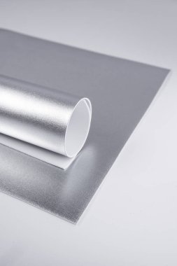 Yuvarlak gümüş karton çarşaf. Parlak isolon çarşaflar. Metalik kağıt. El yapımı materyaller, yuvarlanmış gümüş karton çarşaf. Parlak isolon çarşaflar. Metalik kağıt. El yapımı malzemeler
