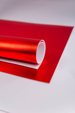 Yuvarlanmış kırmızı karton. Parlak isolon çarşaflar. Izolon. El yapımı malzemeler