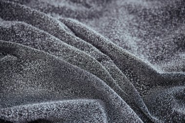 Gümüş buruşuk kumaş, pullu kum. Gri kumaşla örtünmüş. Parlak doku