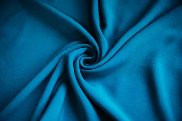 蓝色皱皱巴巴的织物呈褶皱状放在桌子上 上面有窗帘 — 图库照片