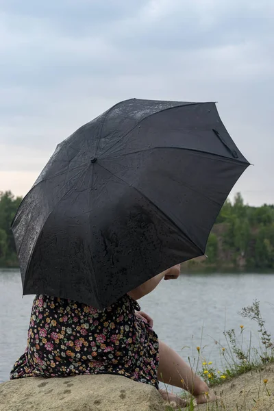 Girl with an umbrella in cloudy weather.