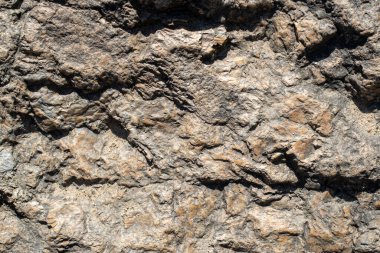 Raw granite rock texture background. Fragment of natural stone wall.