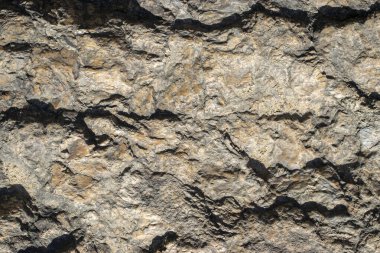 Raw granite rock texture background. Fragment of natural stone wall.