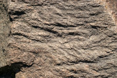 Raw granite rock texture background. Fragment of natural stone wall.