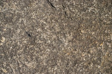 Raw granite rock texture background. Fragment of natural stone wall.