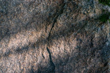 Raw granite rock texture background. Fragment of natural stone wall.