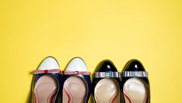 Женская обувь на желтом фоне — стоковое фото