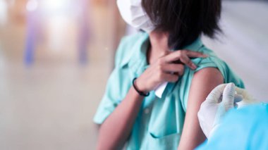 Doktor, Coronavirus veya Covid-19 'u önlemek için üniformalı öğrencilere aşı yapıyor.