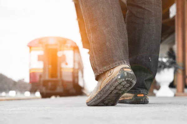 旅行者の男性は スニーカーを履いて電車に歩いています — ストック写真