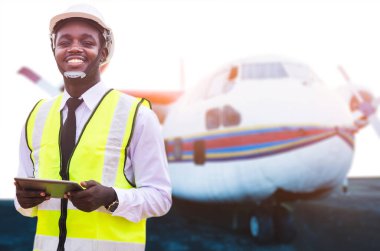 Afrikalı teknisyen uçağı tablet kullanarak tamir ediyor.