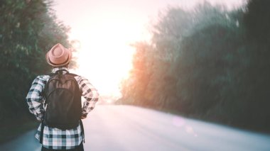 Sırt çantalı Afrikalı gezgin uzun bir yolda yürüyor. Macera yolculuğu kavramı.