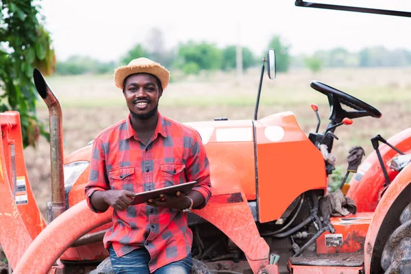 Afrikalı Çiftçi Tarlada Traktörle Çalışıyor Tablet Kullanıyor Tarım Yeniliği Tarım — Stok fotoğraf