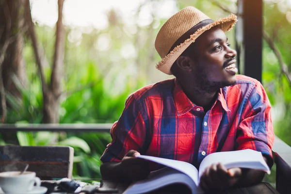 Afrikanischer Reisender Mit Hut Buch Und Einer Tasse Kaffee Denkt — Stockfoto