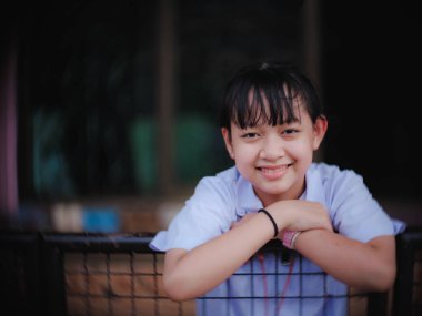 Bayan öğrenci akşam okulunu bitirdikten sonra mutlu bir şekilde gülümsedi ve güldü.