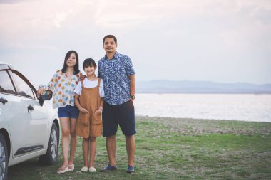Mutlu bir aile babası, annesi ve kızı tropik bir plajda eğleniyor ve yabancı bir arabada. Aile tatili ve seyahat kavramı