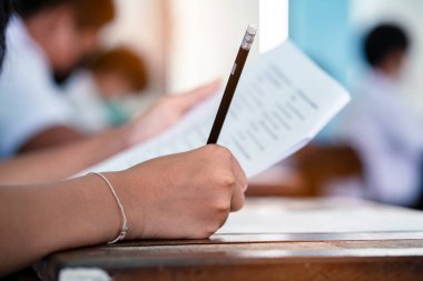 Sınav kağıtlarını okuyan ve alan öğrencilerin el kapaklarını kapatın sınıfta stres ile cevap verin