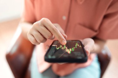 Yakın plan - Kadın cep telefonundaki dijital takas, kripto para birimi gelecekteki fiyat öngörüsü Bitcoin fiyat tablosunu kontrol ediyor.