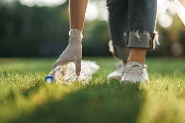 Gönüllü kadın çöp torbasında çöp topluyor. Plastik kirliliği ve çevresel sorun kavramı. Dünyayı yeşillendirmek, çöpsüz gezegen konsepti.