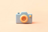 Minimální fotoaparát s objektivem a tlačítkem na pastelovém pozadí. 3D vykreslení