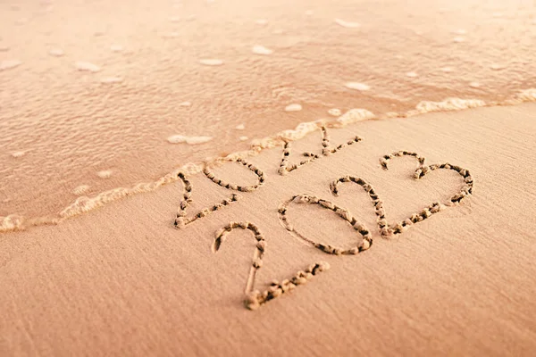 New Year 2023 replace 2022 on the sea beach concept.