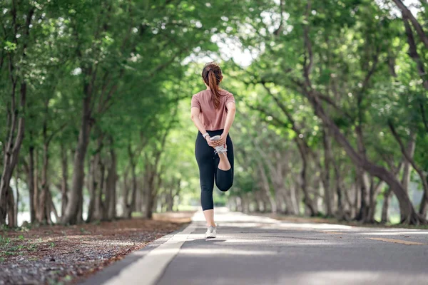 公園で実行する前に足を伸ばすランナー女性 健康的なライフスタイルとスポーツの概念 ウォームアップ — ストック写真