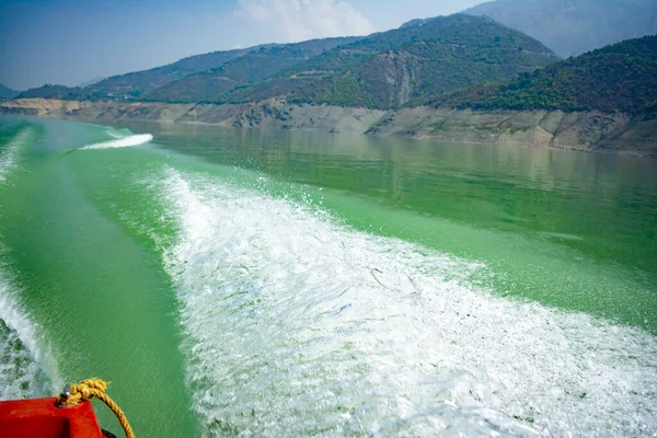 Tehri Lake, water surface behind of fast moving motor boat in Tehri lake. Trail on water surface behind speed boat. Rear view of waves behind the speedy boat