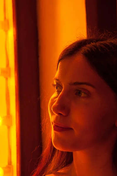 Porträtt Vacker Flicka Nära Nattfönstret Orange Ljus — Stockfoto