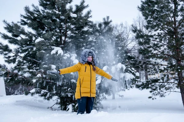 Dziewczyna Żółtej Kurtce Futerkiem Bawi Się Śniegiem Tle Zimowego Lasu — Zdjęcie stockowe