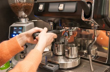 Kadın eli kahve makinesine bir tablet kahve koydu.