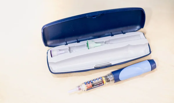 Insulin pen with insulin drop at needle with the box, the equipment for the diabetic patient makes an insulin injection.