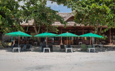 Sandalyeler ve Şemsiye Palm Beach 'te gezginlerin seyahate çıkmasını beklerken plajdaki rahatlama aktivitesi ve tecrit şehri Covid salgınından dolayı. 