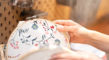 Kadın eli, ahşap işlemeli çerçeve seçiyor ve el işi sırasında dikiş atılıyor. Hafta sonları boş zamanların tadını çıkarıyorum..