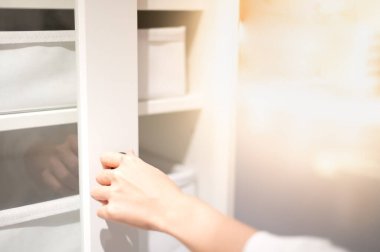 Kadın eli mutfakta beyaz dolabın kapısını açıyor..