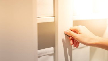 Kadın eli mutfakta beyaz dolabın kapısını açıyor..