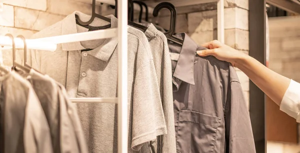 デパートのクロスショップでラックにチェック柄のコットンポロシャツのための男性の手の選択服 衣類製品の価格 プロモーションをチェック — ストック写真