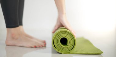 Paspasın üzerinde egzersiz hazırlamak için kadın el yapımı yeşil yoga minderi..